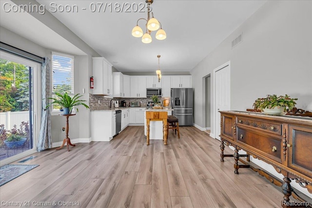 21150 Bryce Ct, Romulus, MI 48174 - kitchen featuring appliances with stainless steel finishes, decorative backsplash, white cabinetry, and light wood finished floors