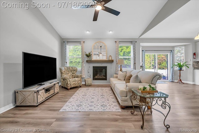 21150 Bryce Ct, Romulus, MI 48174 - living area featuring vaulted ceiling, a high end fireplace, a ceiling fan, wood finished floors, and recessed lighting