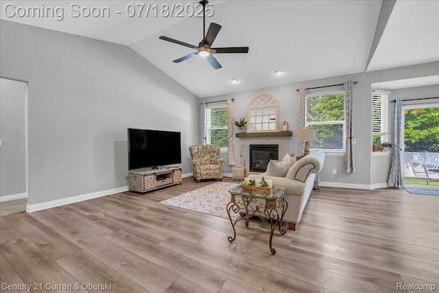 21150 Bryce Ct, Romulus, MI 48174 - living area with healthy amount of natural light, a ceiling fan, lofted ceiling, wood finished floors, and a glass covered fireplace