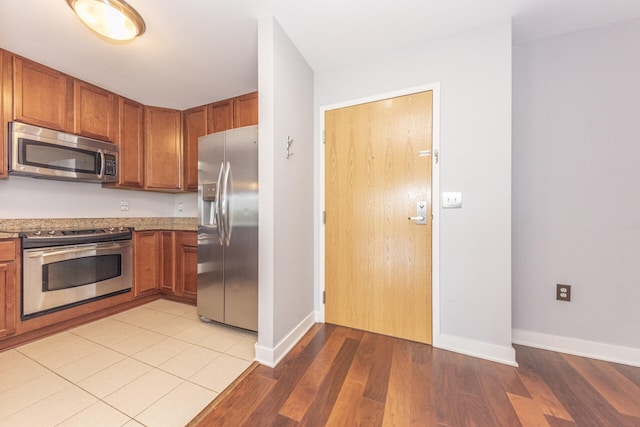 111 N Ashley St Unit 412, Ann Arbor, MI 48104 - kitchen with stainless steel appliances, brown cabinetry, and light wood finished floors