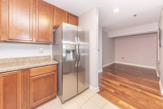 111 N Ashley St Unit 412, Ann Arbor, MI 48104 - kitchen with stainless steel refrigerator with ice dispenser, brown cabinetry, light stone counters, and recessed lighting