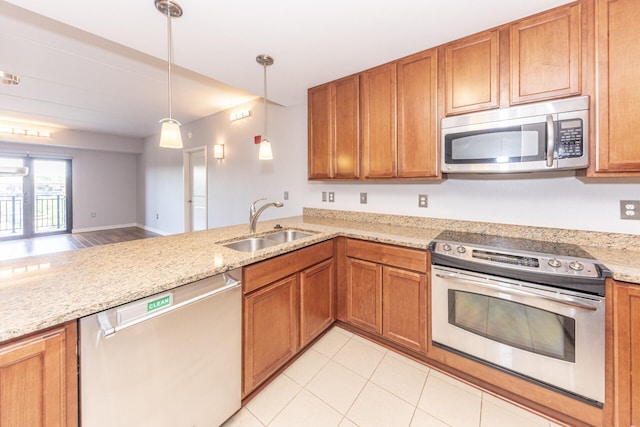 111 N Ashley St Unit 412, Ann Arbor, MI 48104 - kitchen featuring appliances with stainless steel finishes, brown cabinets, decorative light fixtures, a peninsula, and light stone counters