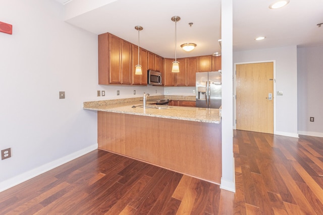111 N Ashley St Unit 412, Ann Arbor, MI 48104 - kitchen featuring appliances with stainless steel finishes, dark wood-type flooring, light stone counters, brown cabinets, and a peninsula