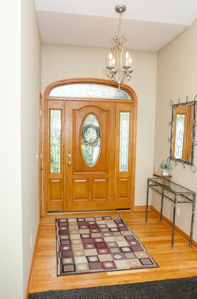 11734 Lindy Ct, Rockford, MI 49341 - entryway featuring a chandelier and wood finished floors