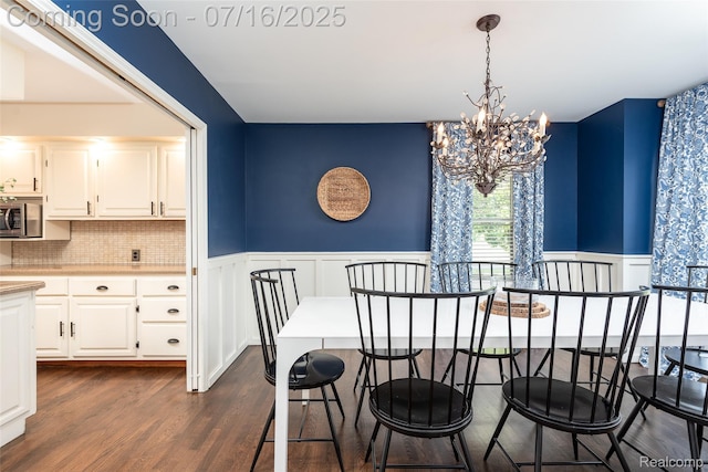 7366 E Maple Ave, Grand Blanc, MI 48439 - dining area with a chandelier, a decorative wall, wainscoting, and dark wood-type flooring