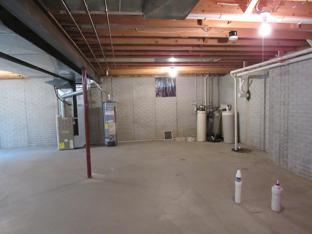 4237 W Grand Blanc Rd, Swartz Creek, MI 48473 - unfinished below grade area featuring heating unit, gas water heater, brick wall, and a water softener system