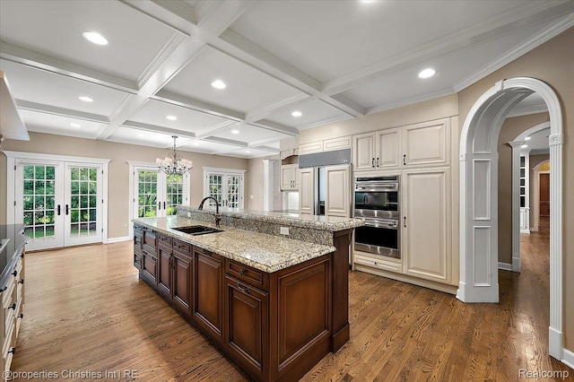 400 Hamilton Rd, Bloomfield, MI 48301 - kitchen with french doors, stainless steel double oven, dark wood finished floors, coffered ceiling, and an island with sink