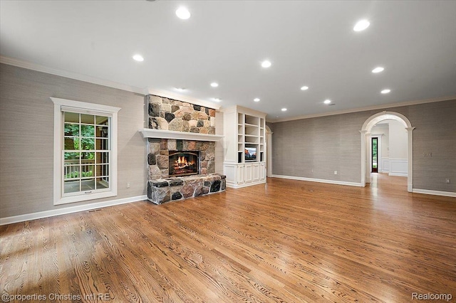 400 Hamilton Rd, Bloomfield, MI 48301 - unfurnished living room with ornamental molding, wood finished floors, a stone fireplace, recessed lighting, and arched walkways