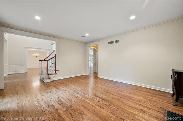 400 Hamilton Rd, Bloomfield, MI 48301 - unfurnished living room with crown molding, wood finished floors, a chandelier, arched walkways, and stairs