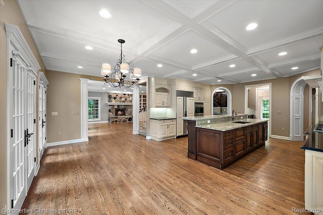 400 Hamilton Rd, Bloomfield, MI 48301 - kitchen featuring arched walkways, a stone fireplace, coffered ceiling, wood finished floors, and recessed lighting
