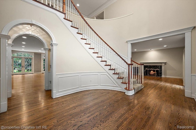 400 Hamilton Rd, Bloomfield, MI 48301 - staircase featuring ornate columns, a premium fireplace, wood finished floors, arched walkways, and ornamental molding