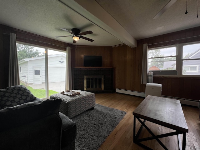 2682 Elmwood Dr, Adrian, MI 49221 - living room featuring a ceiling fan, a baseboard radiator, a textured ceiling, beamed ceiling, and wood finished floors