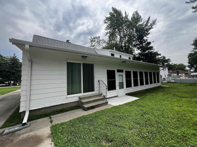 2682 Elmwood Dr, Adrian, MI 49221 - rear view of property with entry steps, a yard, and roof with shingles