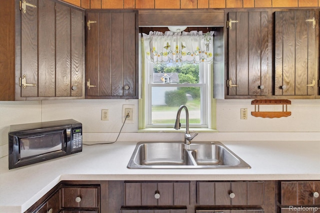 4415 Central St, Columbiaville, MI 48421 - kitchen with light countertops, black microwave, and dark brown cabinets