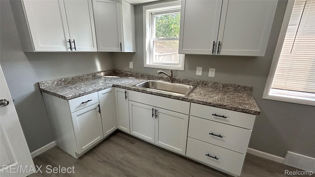 1902 Crestbrook Ln, Flint, MI 48507 - kitchen with white cabinetry and dark stone countertops