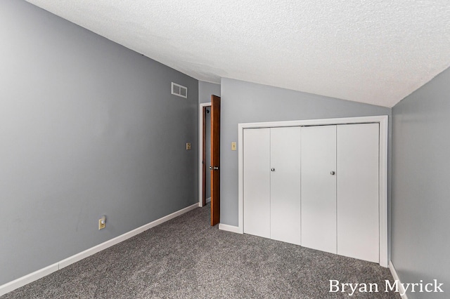 4675 44th St, Holland, MI 49423 - unfurnished bedroom with carpet flooring, vaulted ceiling, a textured ceiling, and a closet