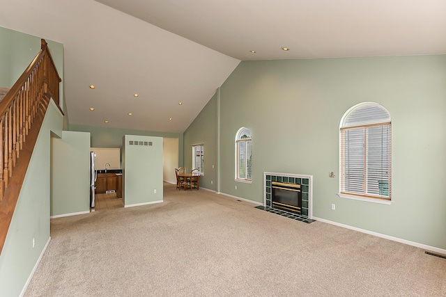 6602 Robindale Dr, Ypsilanti, MI 48197 - unfurnished living room with light carpet, high vaulted ceiling, a tile fireplace, and recessed lighting