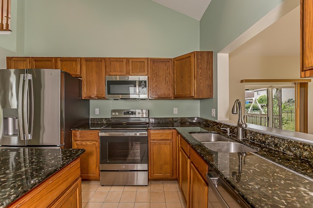 6602 Robindale Dr, Ypsilanti, MI 48197 - kitchen with appliances with stainless steel finishes, high vaulted ceiling, brown cabinets, light tile patterned floors, and dark stone counters