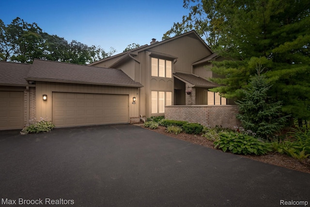 1109 Ivyglen Cir, Bloomfield Hills, MI 48304 - view of front of property featuring brick siding, a garage, asphalt driveway, and a chimney