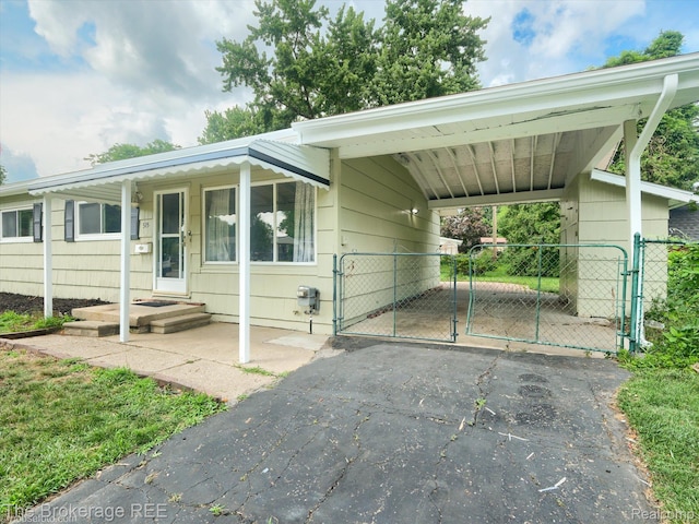 515 Juniper Dr, Davison, MI 48423 - view of front facade with a gate, asphalt driveway, and a carport