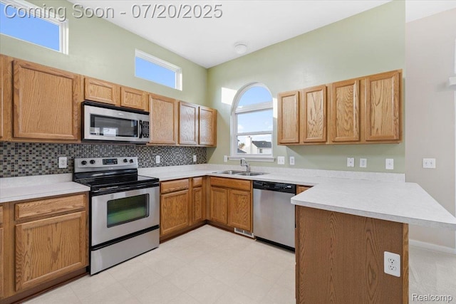 1145 York Ave, Howell, MI 48843 - kitchen with a peninsula, stainless steel appliances, light countertops, tasteful backsplash, and light flooring