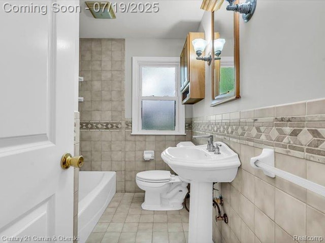 3850 Parker St, Dearborn, MI 48124 - bathroom featuring tile patterned floors, tile walls, a tub, and a wainscoted wall