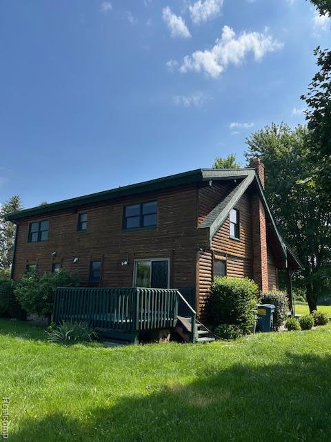20100 Hickory Ridge Rd, Holly, MI 48442 - back of property featuring a wooden deck, a lawn, and a chimney