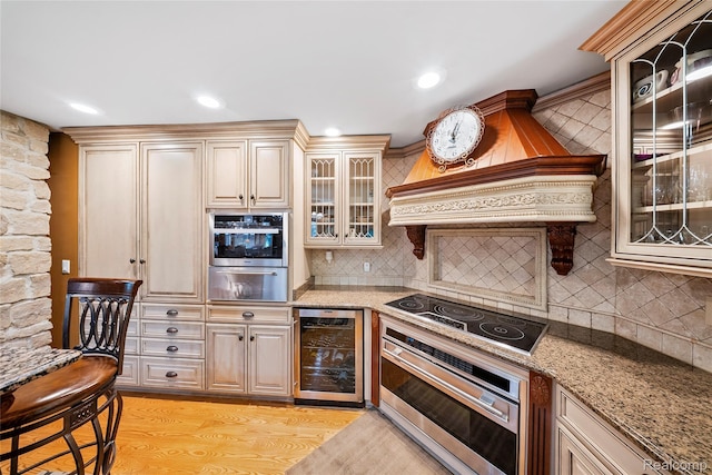 8931 Bridge Rd, Grosse Ile, MI 48138 - kitchen featuring beverage cooler, black electric cooktop, a warming drawer, oven, and light wood-style floors