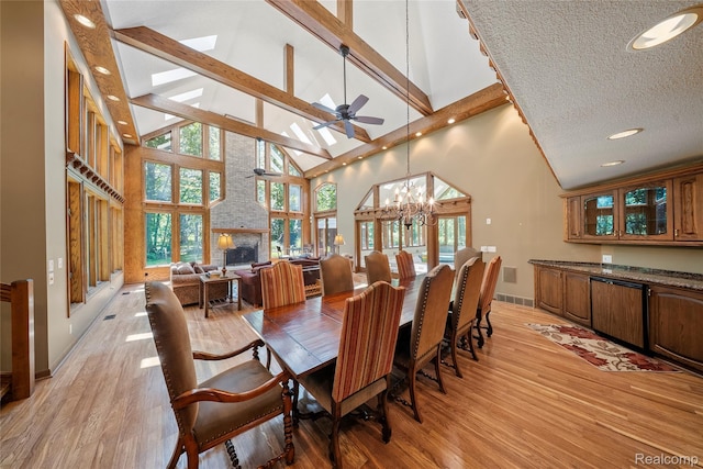 8931 Bridge Rd, Grosse Ile, MI 48138 - dining area with a ceiling fan, high vaulted ceiling, a chandelier, light wood-type flooring, and a skylight