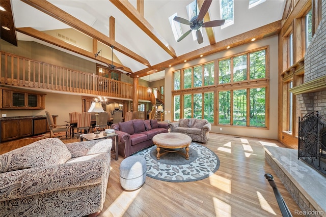 8931 Bridge Rd, Grosse Ile, MI 48138 - living room with high vaulted ceiling, a ceiling fan, a fireplace, plenty of natural light, and beam ceiling