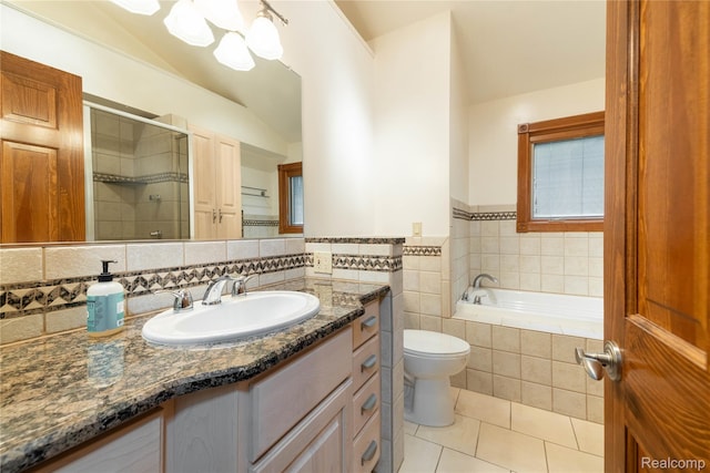21819 Meridian Rd, Grosse Ile, MI 48138 - bathroom with lofted ceiling, tile patterned flooring, vanity, a garden tub, and a stall shower