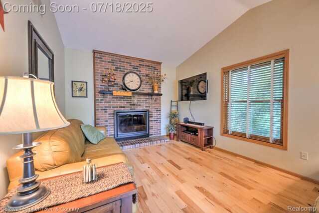 978 Oak Ridge Cir, Brighton, MI 48116 - living area with lofted ceiling, wood finished floors, and a fireplace
