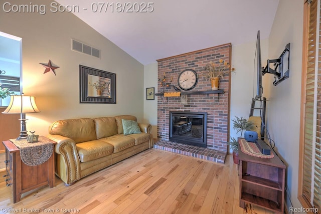 978 Oak Ridge Cir, Brighton, MI 48116 - living room featuring lofted ceiling, wood-type flooring, and a brick fireplace