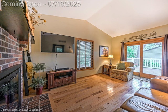978 Oak Ridge Cir, Brighton, MI 48116 - living area featuring vaulted ceiling, hardwood / wood-style floors, and a brick fireplace