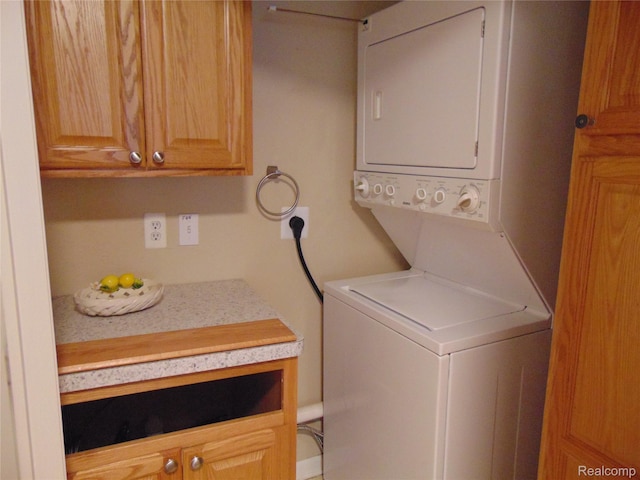 1429 Millbrook Trl, Ann Arbor, MI 48108 - laundry area featuring stacked washing machine and dryer and cabinet space