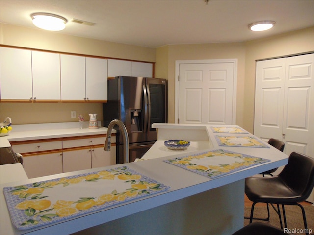 1429 Millbrook Trl, Ann Arbor, MI 48108 - kitchen with stainless steel fridge, light countertops, a breakfast bar area, and white cabinetry