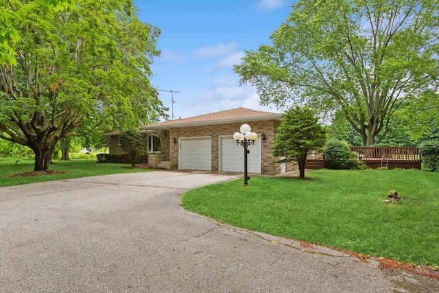 13613 Log Cabin Rd, Three Oaks, MI 49128 - ranch-style home with a front lawn, concrete driveway, a garage, brick siding, and a deck