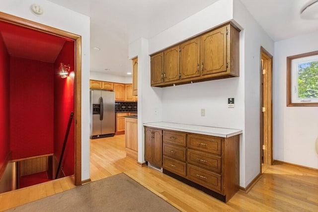13613 Log Cabin Rd, Three Oaks, MI 49128 - kitchen with stainless steel fridge with ice dispenser, light wood-style floors, backsplash, and brown cabinets