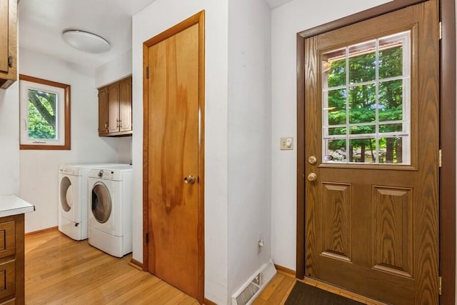 13613 Log Cabin Rd, Three Oaks, MI 49128 - laundry room featuring cabinet space, separate washer and dryer, plenty of natural light, and light wood finished floors