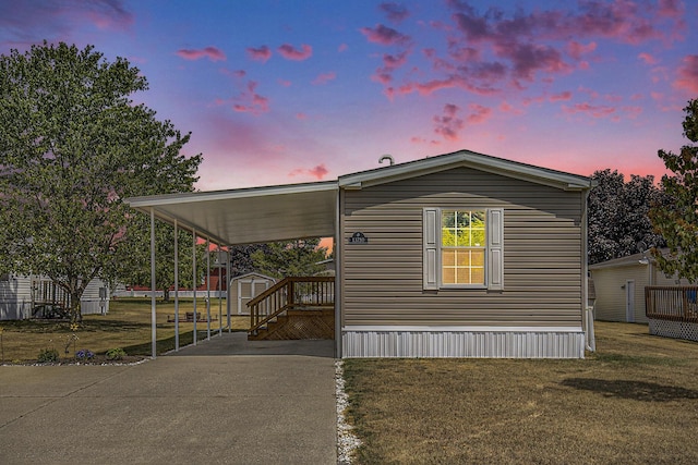 13750 Primrose Ln, Cedar Springs, MI 49319 - manufactured / mobile home with a storage shed, concrete driveway, a lawn, and an attached carport