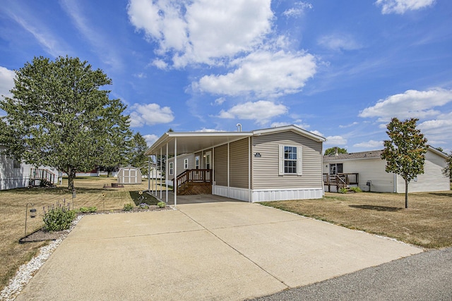 13750 Primrose Ln, Cedar Springs, MI 49319 - manufactured / mobile home featuring a storage unit, driveway, and an attached carport