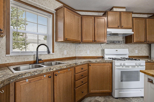 13750 Primrose Ln, Cedar Springs, MI 49319 - kitchen with gas range gas stove, under cabinet range hood, brown cabinetry, a textured ceiling, and dark countertops