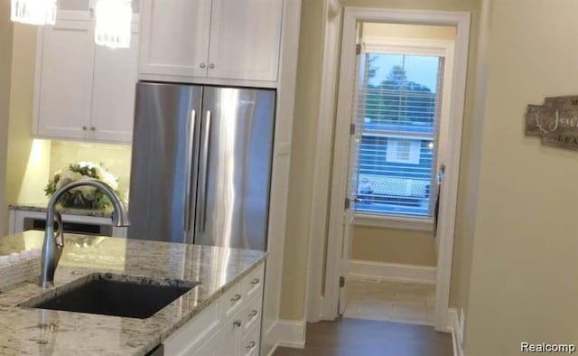 7345 Verona Dr, West Bloomfield, MI 48322 - kitchen with white cabinets, freestanding refrigerator, light stone counters, and decorative backsplash
