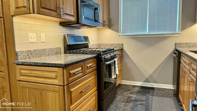 510 Martin St, Owosso, MI 48867 - kitchen featuring stainless steel appliances, backsplash, stone counters, and brown cabinetry