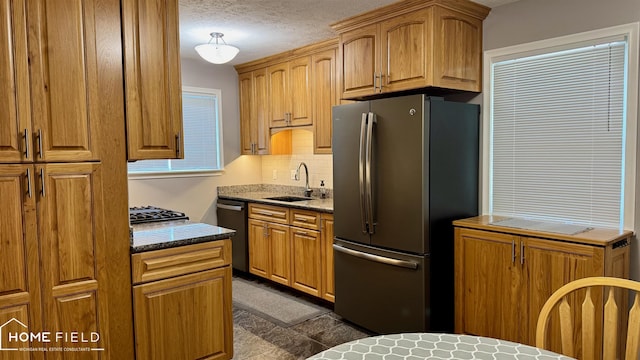 510 Martin St, Owosso, MI 48867 - kitchen with appliances with stainless steel finishes, tasteful backsplash, dark stone countertops, and a textured ceiling