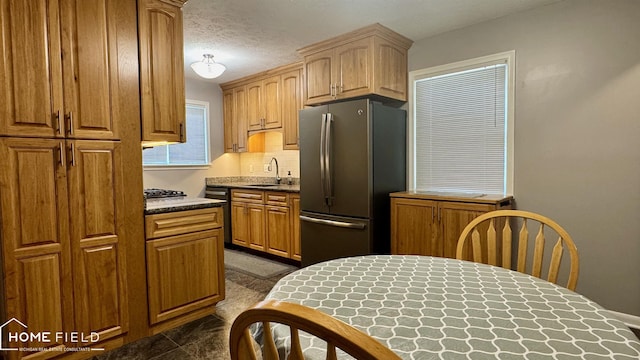 510 Martin St, Owosso, MI 48867 - kitchen featuring freestanding refrigerator, backsplash, and dishwashing machine