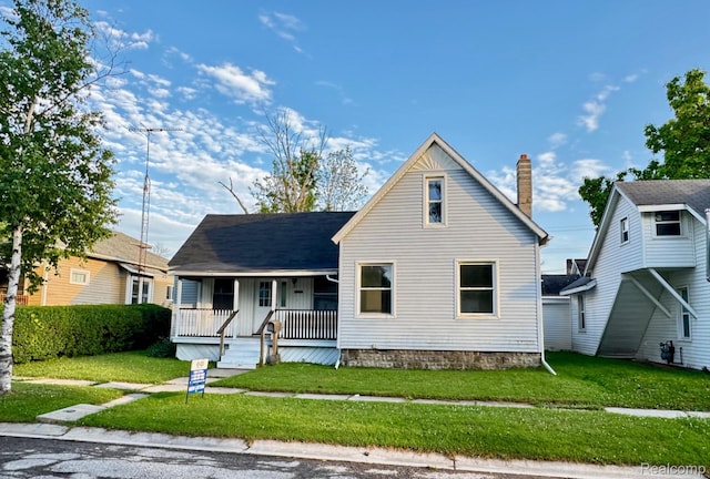 1128 White St, Port Huron, MI 48060 - view of front facade featuring a porch, a front yard, and a chimney