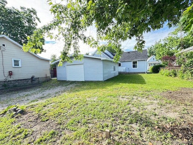 1128 White St, Port Huron, MI 48060 - rear view of property with a garage, an outdoor structure, a lawn, and driveway