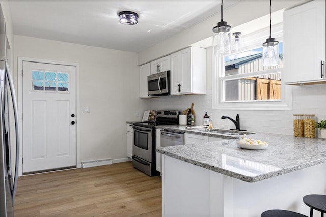 10965 Bunton Rd, Willis, MI 48191 - kitchen with stainless steel appliances, a peninsula, plenty of natural light, and a breakfast bar area