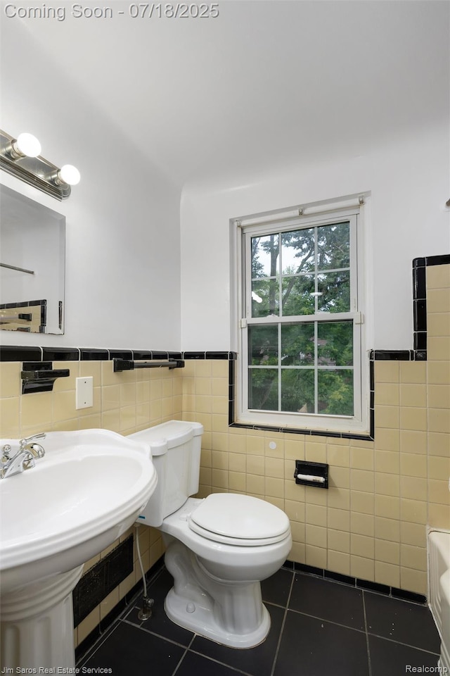 302 Alter Rd, Detroit, MI 48215 - bathroom with tile patterned flooring, tile walls, a wainscoted wall, and a tub to relax in
